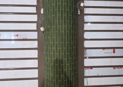 Ronde kolom betegeld met groene wandtegels in winkelpand - Uw tegelidee