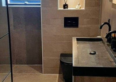 Taupe badkamer met zwarte wastafel en verlichte nis - tegelwerk Uw tegelidee